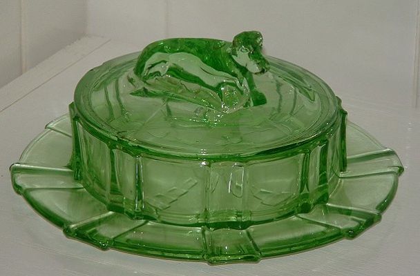 Butter dish with lid and cow handle
Uranium green glass butter dish and lid. Handle of lid is formed by a cow. Unknown maker. Glows brightly even in sunshine!
