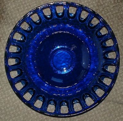 Couronne blue dish
With pierced edge. 16 inches in diameter, 4? inches high. Comes in 2 sizes* - this is the larger size, and has also been seen in yellow, and in a footed blue version.

Clear version also available in 3 sizes. 
http://www.couronneco.com/g7272-wholesale-bowl.htm
