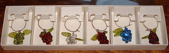 Wine glass identifiers
Grapes and leaves glass identifiers on metal ring. Slip one around each wineglass stem to identify which glass belongs to whom. Made in India. Contemporary.

We use them as tree decorations on our small fibre optic Xmas tree. 
Keywords: Lampwork India
