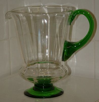 Unknown green/clear footed jug - side view
Unknown maker. Has polished pontil. Body of jug is optic ribbed.  7" tall, top is 5" diameter.
Keywords: mouldblown