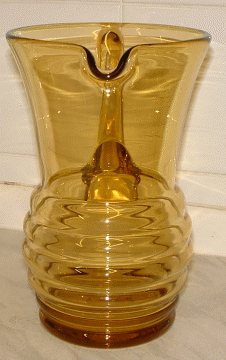 Seneca tall amber jug - view 4
Amber jug with beehive shaped lower half, has polished pontil and applied handle.  Now known to be Seneca Glass Company, of Morgantown, West Virginia pattern "Streamline", design Patent number "d 60637" from 1937. [Source: Mike (butchiedog) on the Glass Message Board]
Keywords: Seneca mouldblown USA