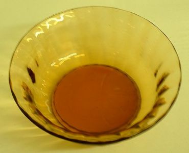 Unknown golden amber dish - top view
One of four dessert dishes. Polished pontil mark. Ribbed sides. Very heavy for their size. 5" diameter. 2" high. Unknown maker, possibly Webb
